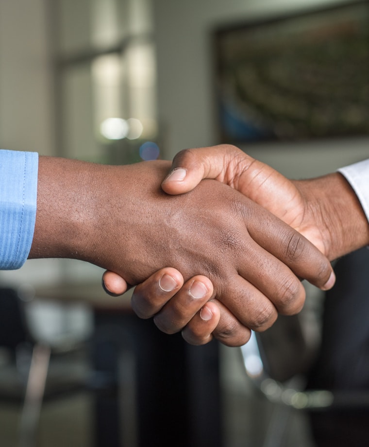 Advisor and customer shaking hands on a loan agreement